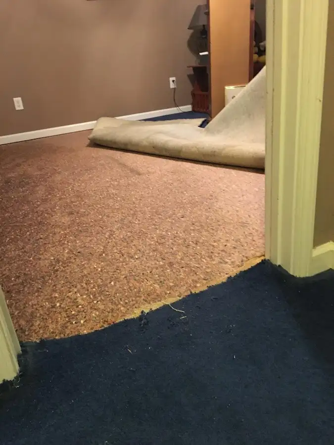 Carpet pad removal revealing water damage during Water Mitigation Services in White City